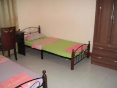 a room with two beds and a dresser at JCP Room Rentals in Manila