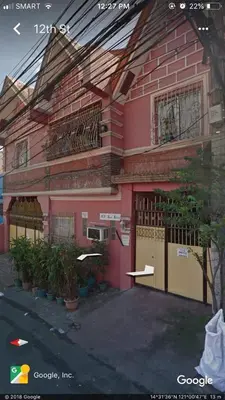 a pink house with a fence in front of it at JCP Room Rentals in Manila