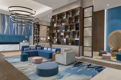 a living room with blue furniture and a chandelier at Citadines Bay City Manila in Manila