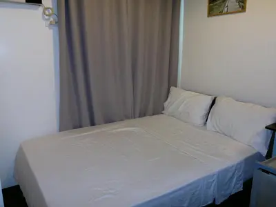 a bed with white sheets and pillows in a room at Makati Condo Edsa MRT Magallanes Station Chino Roces Ave cor EDSA IT Hub ONE Ayala Alphaland WiFi by 24K Residences in Manila