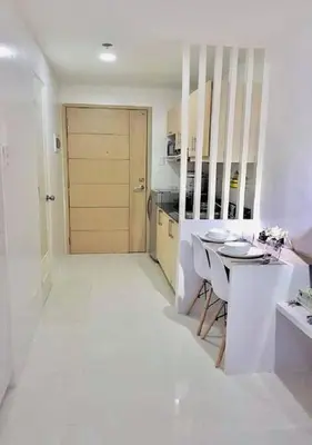 a white kitchen with a table and a door at EV Place in Manila