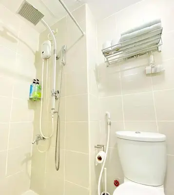 a white bathroom with a shower and a toilet at Will’s Place at Jazz Makati in Manila