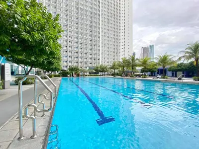 a large swimming pool in front of a tall building at Will’s Place at Jazz Makati in Manila