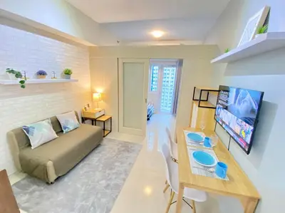 a living room with a couch and a tv at Will’s Place at Jazz Makati in Manila