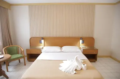 a bedroom with a bed with a bird on it at Hotel Soriente in Manila