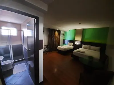 a hotel room with a bed and a bathroom at Lorenzzo Suites Hotel Makati in Manila
