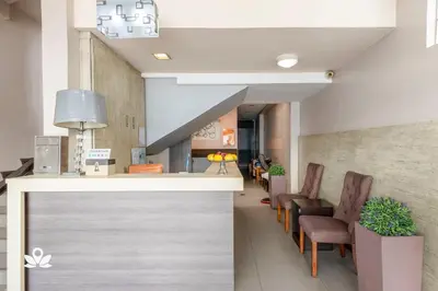 a lobby with chairs and a counter in a building at Lorenzzo Suites Hotel Makati in Manila