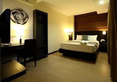 a hotel room with a bed and a desk at Lorenzzo Suites Hotel Makati in Manila