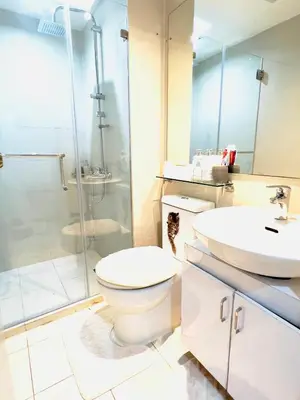 a bathroom with a toilet and a sink and a shower at Azure Urban Resort Residences - The Paris Hilton Beach Club in Manila