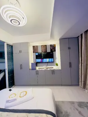a bedroom with a bed and a flat screen tv at Azure Urban Resort Residences - The Paris Hilton Beach Club in Manila