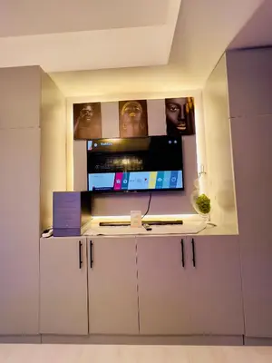 a room with a tv on top of a white cabinet at Azure Urban Resort Residences - The Paris Hilton Beach Club in Manila