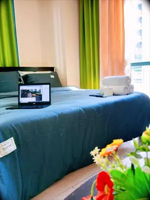 a laptop computer sitting on top of a bed at The Palm Tree Condotel Manila Airport in Manila