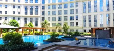 a large building with a swimming pool in front of a building at The Palm Tree Condotel Manila Airport in Manila
