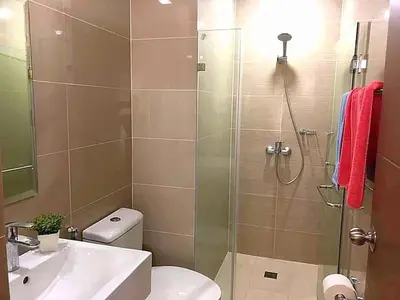 a bathroom with a shower and a toilet and a sink at The Palm Tree Condotel Manila Airport in Manila