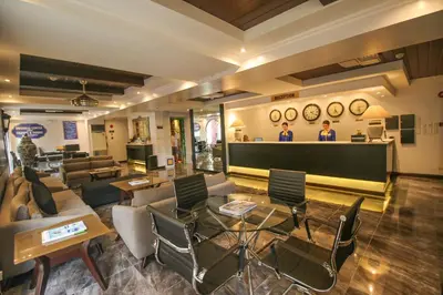 a lobby with a waiting area with chairs and tables at Royal Bellagio Hotel in Manila