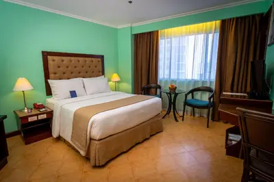 a hotel room with a bed and a television at Royal Bellagio Hotel in Manila