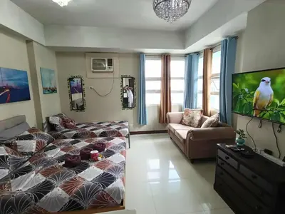 a living room with a bed and a couch at Condo Unit walking distance to Manila Airport (NAIA Terminal 3) in Manila