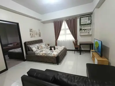 a living room with a couch and a television at Condo Unit walking distance to Manila Airport (NAIA Terminal 3) in Manila
