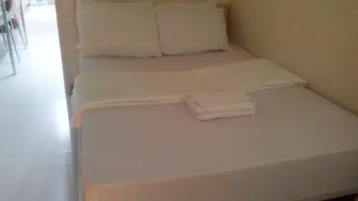 a bed with two pillows and two towels on it at CHATEAU ELYSEE a6 near AIRPORT Wifi Kitchen in Manila