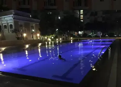 a person swimming in a pool at night at CHATEAU ELYSEE a6 near AIRPORT Wifi Kitchen in Manila