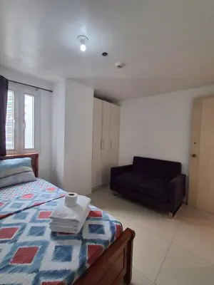 a bedroom with a bed and a couch at Spacious 2BR in Jazz Residences Makati in Manila