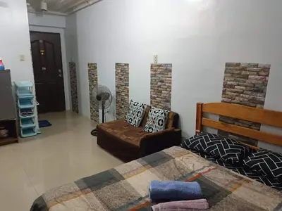 a bedroom with a bed and a couch and a chair at Mavs transient inn kassel residences in Manila