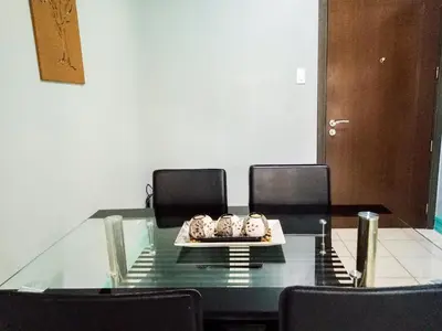 a glass table with chairs and a plate of food on it at Forbes Area BGC Taguig Manila in Manila