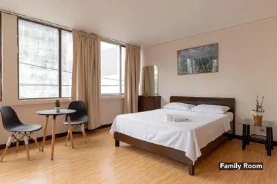 a bedroom with a bed and a table and chairs at Victoria Mansions in Manila
