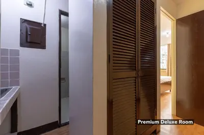 a bathroom with a wooden door and a mirror at Victoria Mansions in Manila