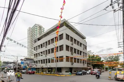 a building on a city street with christmas lights at Victoria Mansions in Manila