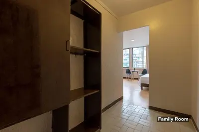 a hallway with a door to a room with a bedroom at Victoria Mansions in Manila