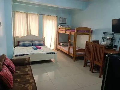 a bedroom with two bunk beds and a desk at Kassel residence Mhavic Family room good for 5guest in Manila