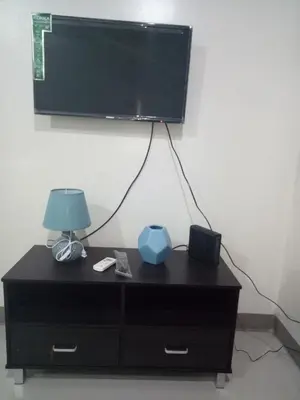 a black dresser with a lamp and a television on a wall at Kassel residence Mhavic Family room good for 5guest in Manila