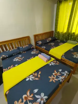 two beds sitting next to each other in a bedroom at Kassel residence Mhavic Family room good for 5guest in Manila