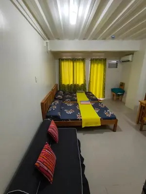 a bedroom with a bed and a couch in it at Kassel residence Mhavic Family room good for 5guest in Manila