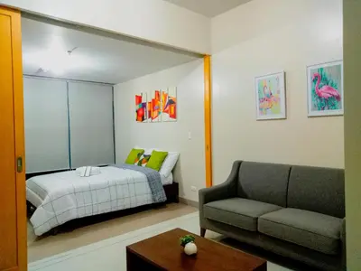 a living room with a bed and a couch at Uptown Mall Area Fort Bonifacio Manila in Manila
