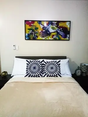 a bedroom with a bed with two pillows on it at Uptown Mall Area Fort Bonifacio Manila in Manila