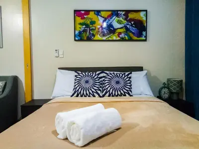 a bedroom with a bed with a white towel on it at Uptown Mall Area Fort Bonifacio Manila in Manila