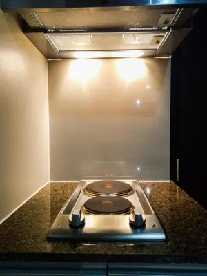 a stove top in a kitchen with a light at Uptown Mall Area Fort Bonifacio Manila in Manila
