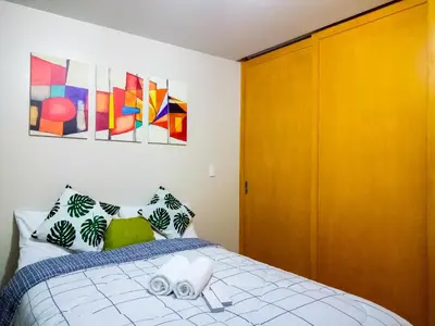 a bedroom with a bed and a wooden cabinet at Uptown Mall Area Fort Bonifacio Manila in Manila
