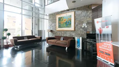 a lobby with two couches and a painting on the wall at RedDoorz Plus @ E Rodriguez Corner Banawe in Manila