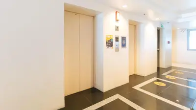 a hallway with white walls and black tile floors at RedDoorz Plus @ E Rodriguez Corner Banawe in Manila