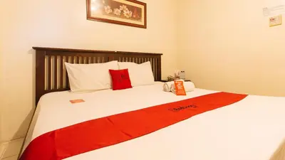 a bed with a red and white blanket on it at RedDoorz Plus @ E Rodriguez Corner Banawe in Manila