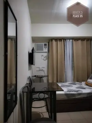 a small room with a bed and a table and a mirror at Macks Awesome Place 05 with Netflix and FastUnliwifi in Manila