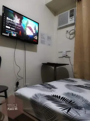 a bedroom with a bed with a flat screen tv on the wall at Macks Awesome Place 05 with Netflix and FastUnliwifi in Manila