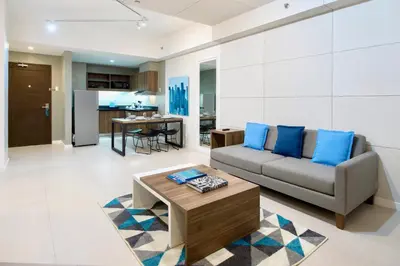 a living room with a couch and a table at The Sphere Serviced Residences Managed by HII in Manila