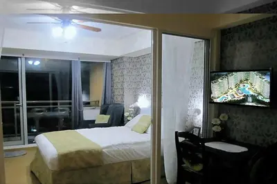 a bedroom with a bed and a sliding glass door at AZURE C5 MAN-MADE BEACH BALCONY Multiple Units in Manila