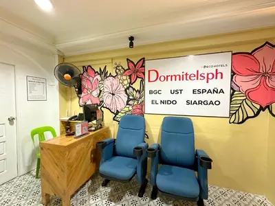 a waiting room with two blue chairs and a sign at Dormitelsph UST in Manila