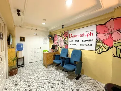 a waiting room with two blue chairs and a sign at Dormitelsph UST in Manila