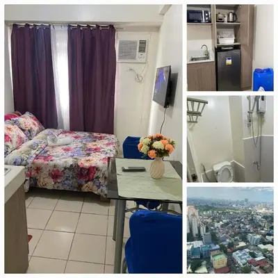 a hotel room with a bed and a table with flowers at Shanilyn Residency Urban Deca Towers EDSA Mandaluyong,UNLIMITED INTERNET AND NETFLIX in Manila